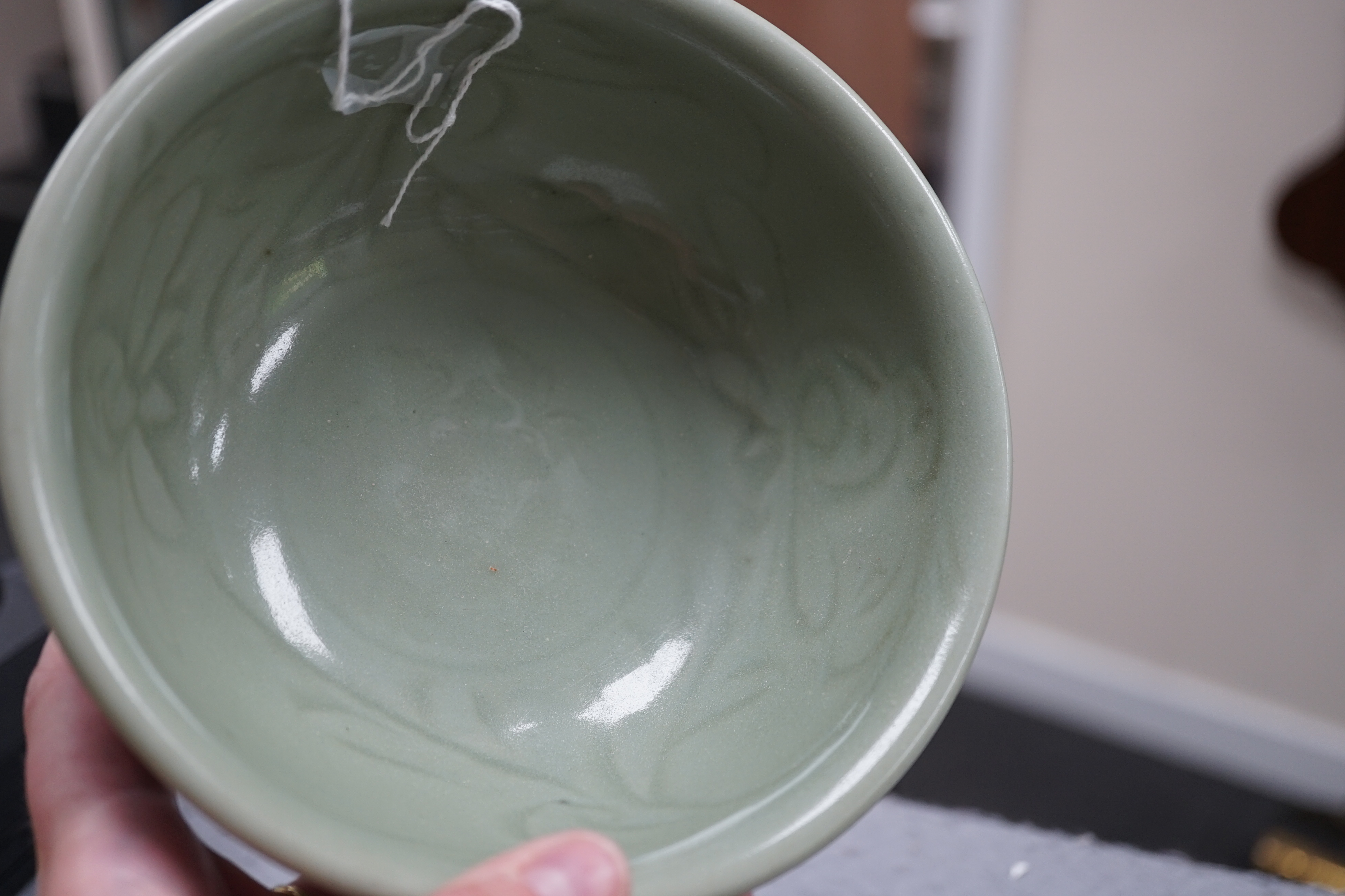 A Chinese Longquan celadon bowl, the interior carved with lotus flowers and the exterior with foliate lappets, 15.2cm diameter., Provenance - Robert Ricketts collection, formerly sold by Robert McPherson, London and S. M